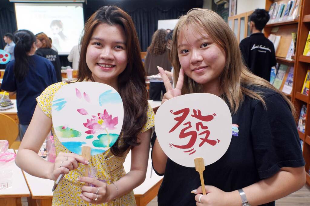 ▲大葉大學馬來西亞學生陳心怡(右)在扇子上畫了發。(圖/記者林明佑翻攝)